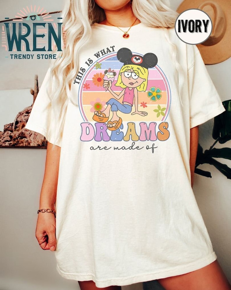 Puede incluir: Una camiseta blanca con un gr&aacute;fico de estilo retro que presenta a una ni&ntilde;a de dibujos animados con orejas de Mickey Mouse y sosteniendo un cono de helado. El gr&aacute;fico dice "This is what dreams are made of".