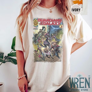 Pu&ograve; includere: Una maglietta bianca con una grafica in stile fumetto vintage dei Guardiani della Galassia. La grafica presenta i personaggi del film, tra cui Star-Lord, Gamora, Drax, Rocket e Groot. Il testo "Guardians of the Galaxy" &egrave; stampato in lettere rosse e nere. L'anno "2023" &egrave; stampato nell'angolo in alto a sinistra della grafica.