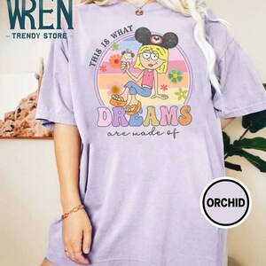 Puede incluir: Una camiseta morada con un gr&aacute;fico retro de un personaje de dibujos animados con orejas de Mickey Mouse y sosteniendo un cono de helado. El gr&aacute;fico est&aacute; rodeado de un c&iacute;rculo con el texto "This is what dreams are made of".
