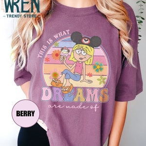 Puede incluir: Camiseta morada con un gr&aacute;fico de estilo retro de una ni&ntilde;a de dibujos animados con orejas de Mickey Mouse y sosteniendo un cono de helado. El gr&aacute;fico dice "This is what dreams are made of".
