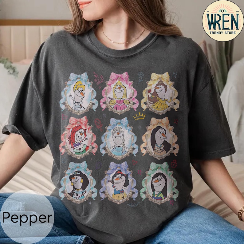 Puede incluir: Camiseta gris oscuro con retratos de dibujos animados de personajes animados en marcos ornamentados. Los retratos incluyen personajes con varios peinados y atuendos, sobre un fondo oscuro. La camiseta tiene el texto "Pepper" en la parte inferior izquierda y un logo "Wren Trendy Store".