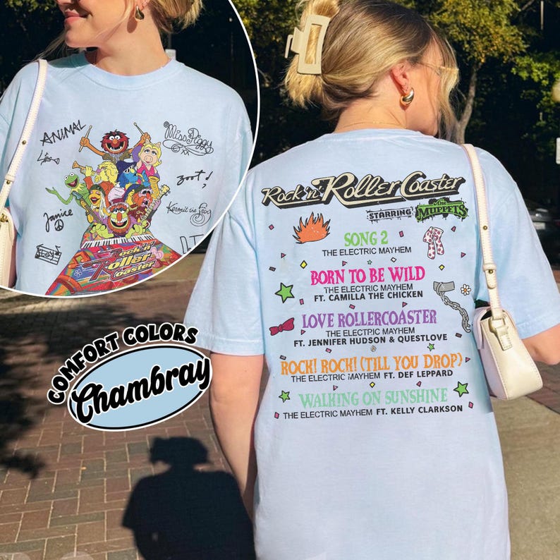 May include: Pale blue t-shirt with a graphic of Muppets characters and the text "Rockin' Roller Coaster". The back of the shirt lists song titles and artist names. The shirt is made of Chambray Comfort Colors.
