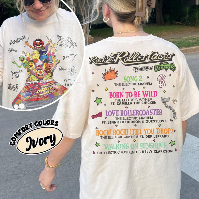 May include: Ivory t-shirt with a graphic of Muppets characters and the text "Rockin' Roller Coaster." The back of the shirt lists song titles and performers. The shirt also has the text "Comfort Colors."
