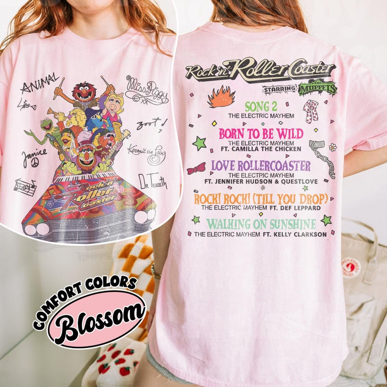 May include: Pale pink t-shirt with a graphic of the Muppets on a roller coaster, with text including "Rockin' Roller Coaster" and song titles. The shirt also has the words "Comfort Colors" and "Blossom".