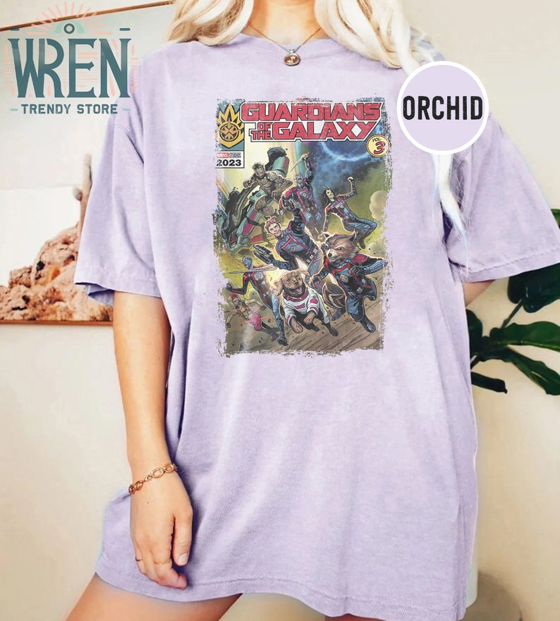 Pu&ograve; includere: Una maglietta viola con una grafica della copertina del fumetto Guardiani della Galassia. La copertina presenta i personaggi dei Guardiani della Galassia, tra cui Star-Lord, Gamora, Drax, Rocket Raccoon e Groot. La copertina del fumetto &egrave; intitolata "Guardiani della Galassia Vol. 3" e ha l'anno 2023 stampato su di essa.