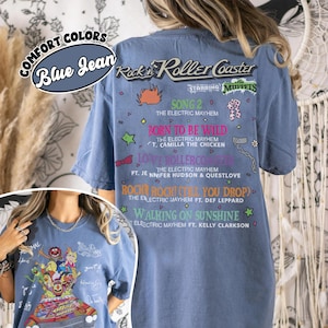 May include: Blue jean comfort colours t-shirt featuring a graphic of the Muppets' Rock 'n' Roller Coaster. The back of the shirt lists song titles like "Born to be Wild" and "Walking on Sunshine".