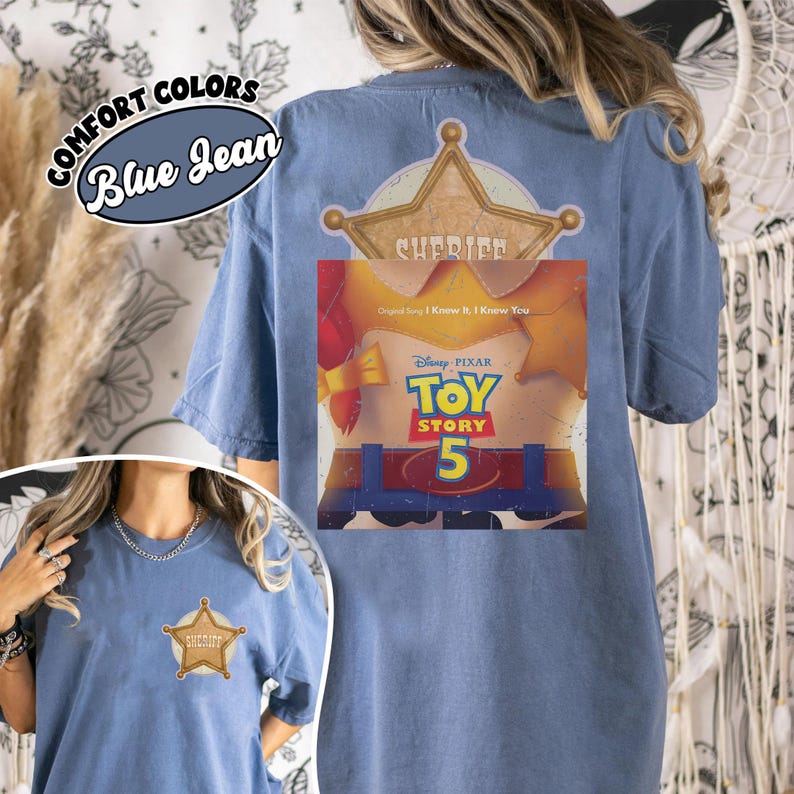 Puede incluir: Una camiseta color azul jean con un peque&ntilde;o gr&aacute;fico de estrella de sheriff en el pecho izquierdo. La parte posterior muestra una estrella de sheriff grande y un gr&aacute;fico de Toy Story 5 con el texto Disney Pixar Toy Story 5 y Original Song I Know It I Know You.