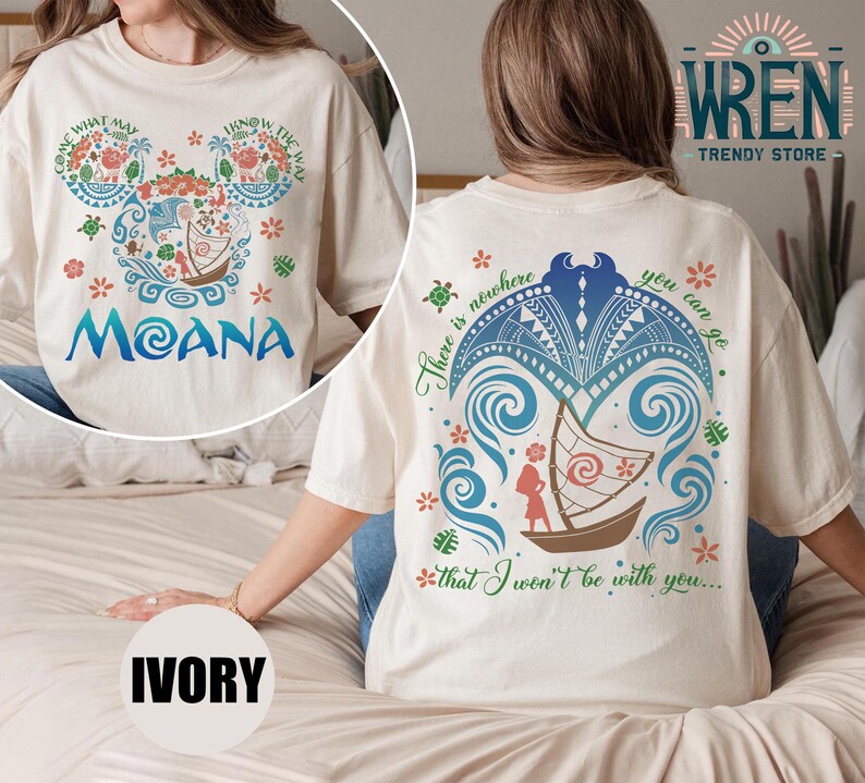 May include: A white t-shirt with a colorful design of a boat and waves on the back. The front of the shirt has a Mickey Mouse head design with the words "Come What May" and "Know The Way" on the ears. The word "Moana" is printed below the Mickey Mouse head. The shirt is available in ivory.