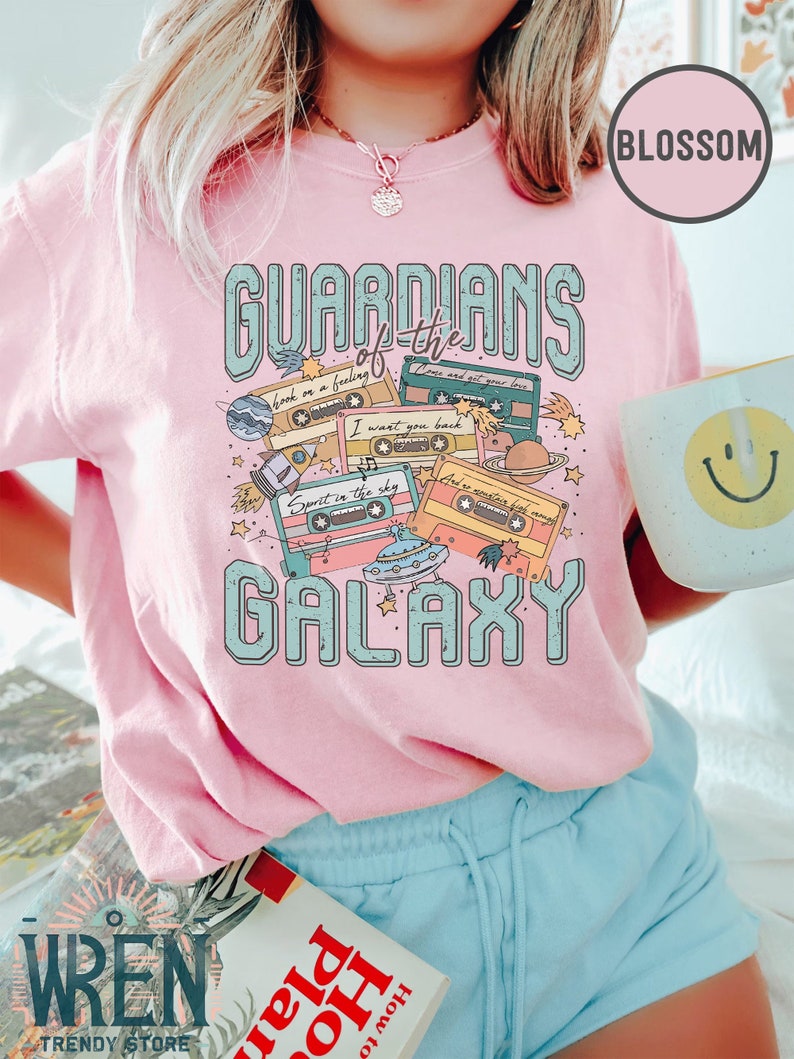 K&ouml;nnte beinhalten: Rosa T-Shirt mit einem Aufdruck von Kassetten und dem Text "Guardians of the Galaxy".
