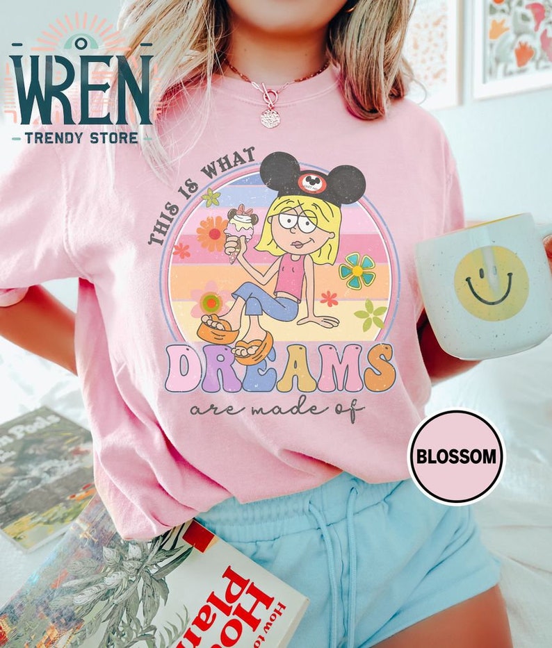 Puede incluir: Camiseta rosa con un gr&aacute;fico retro de una ni&ntilde;a de dibujos animados con orejas de Mickey Mouse y sosteniendo un cono de helado. El gr&aacute;fico dice "This is what dreams are made of".