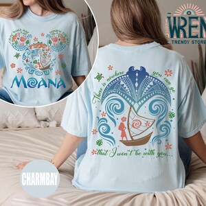 May include: Light blue t-shirt with a graphic print of a cartoon character with the text "Moana" and the phrase "There is nowhere you can go that I won't be with you..." on the back.