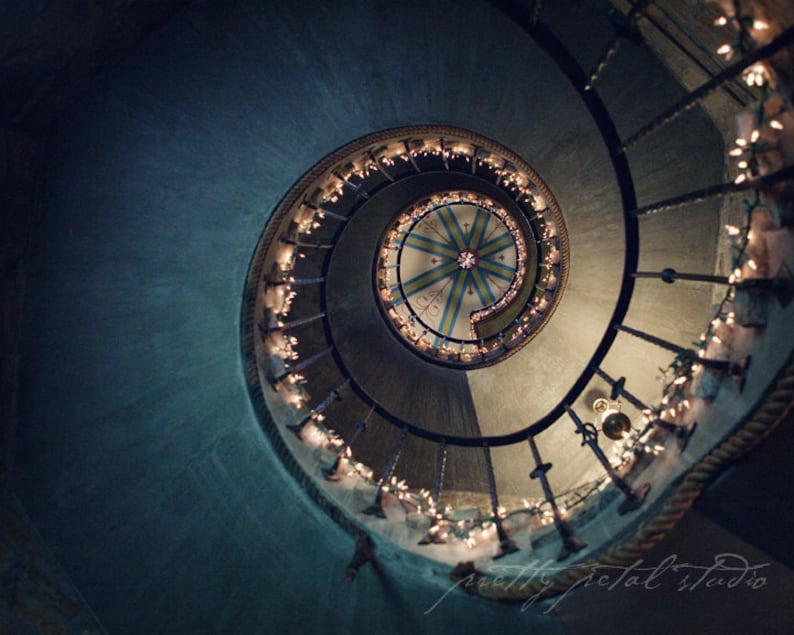 a spiral staircase with christmas lights on it