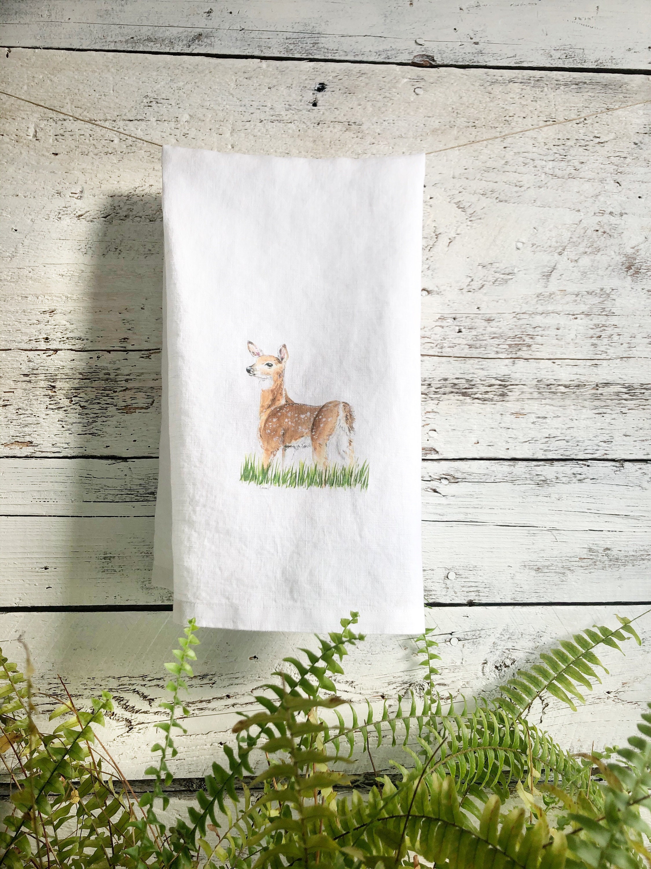 Image of Tea towel with a print of a deer and hydrangeas