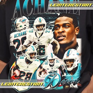 May include: Black t-shirt featuring a graphic of football players in white and teal uniforms. The text "ACHANE" and "Devon" are displayed in teal and white. The shirt has a vintage, distressed look.