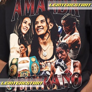 May include: Black t-shirt with a collage of photos of Amanda Serrano, a professional boxer. The shirt features the text "Amanda Serrano" in a red and white font.