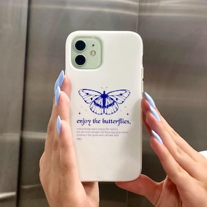 May include: White phone case with a blue butterfly graphic and the text "enjoy the butterflies, enjoy being naive, enjoy the nerves, the pressure people not knowing your name, embrace the good ones all that sull DR3".