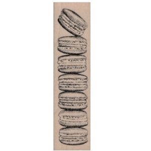 May include: A stack of seven macarons, each with a different color and flavor, arranged vertically on a wooden surface.