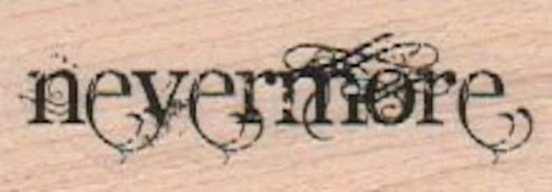 Puede incluir: Un sello de madera decorativo con la palabra "nevermore" en una fuente estilizada con adornos ornamentados.