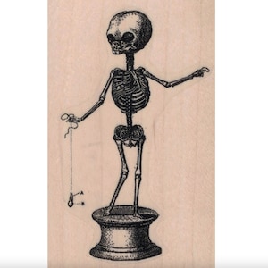 May include: A black and white illustration of a skeleton standing on a pedestal. The skeleton is holding a string in its left hand and pointing with its right hand.