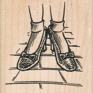 May include: A pair of black heeled shoes with a bow on the toe and white socks. The shoes are standing on a tiled floor.