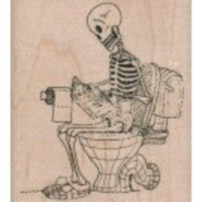 May include: A black and white rubber stamp featuring a skeleton sitting on a toilet, reading a newspaper and holding a roll of toilet paper.