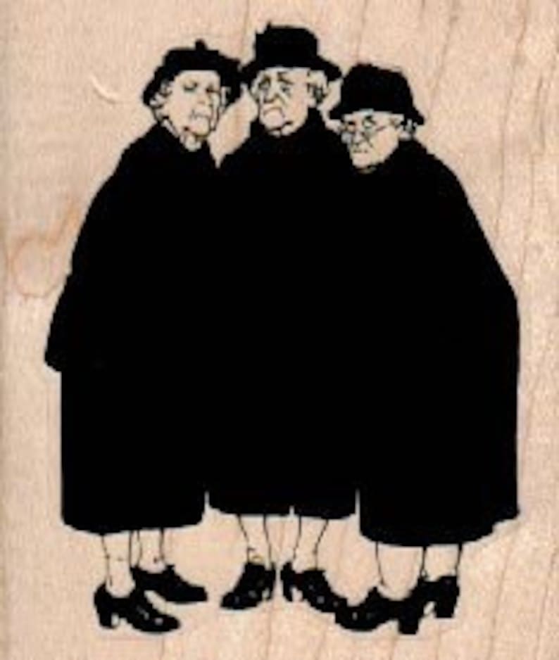 May include: Three women wearing black coats and hats stand together. They are all looking at the camera.
