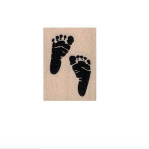 May include: A rubber stamp with two black baby footprints.