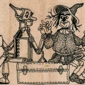 Op de afbeelding: Een zwart-witte illustratie van de Tin Man en de Vogelsverschrikker uit The Wizard of Oz. De Tin Man houdt een koffer vast en de Vogelsverschrikker zit op de koffer. De Tin Man heeft een strikje en de Vogelsverschrikker heeft een hoed.