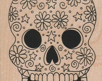 May include: A black and white line drawing of a sugar skull with a floral and star pattern. The skull has a large smile with teeth and a heart-shaped nose.