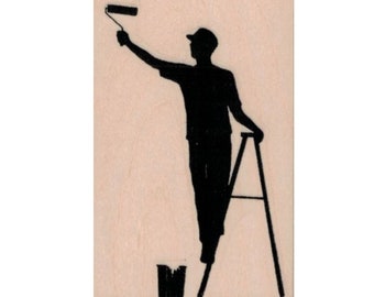 Puede incluir: Silueta de una persona pintando en una escalera. La persona sostiene un rodillo de pintura y está de pie en una escalera de tijera. Hay un cubo de pintura en el suelo.