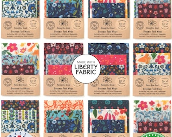 May include: Twelve sets of three beeswax food wraps featuring various floral and botanical patterns in colors including blue, red, orange, and green. Each set is secured with a tan paper band labeled Honey Bee Good Beeswax Food Wraps.