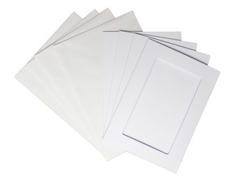 Op de afbeelding: Een set witte passe-partouts met één mat met een rechthoekige opening voor een foto.