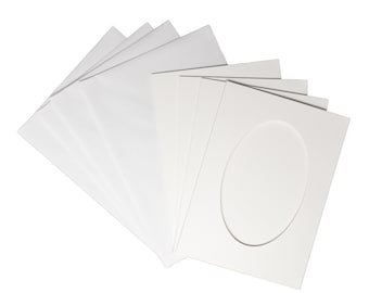 Op de afbeelding: Een pak wit cardstock papier met een ovale uitsparing in het midden van een van de vellen. Het papier is perfect voor knutselen en scrapbooking.