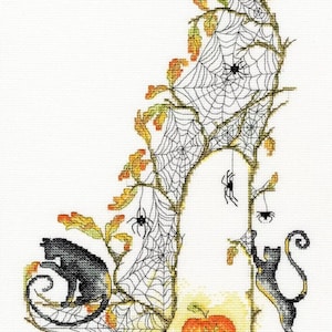 Peut inclure: Un motif de point de croix noir et blanc d'une chaussure à talon haut avec un motif de toile d'araignée. Deux chats noirs sont de chaque côté de la chaussure, et une citrouille sculptée est devant la chaussure.