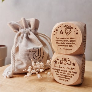 Puede incluir: Dos bloques de madera con dichos e ilustraciones grabados. El bloque superior tiene un racimo de uvas y el texto "Gut zusammen leben, nehmen, teilen, geben. Wenn jeder etwas hat, werden alle satt. amen". El bloque inferior tiene una vaca y el texto "lieber Gatt, heute gab es Zank und Streit. es tut mir leid. Gib uns zum Vertragen Mut, dann wird alles wieder gut."