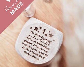 Puede incluir: Un bloque de madera con el número 1 y las palabras "Ein kleiner Engel sagt: gute Nacht" grabadas. El bloque está rodeado de diseños de estrellas. La palabra "Hand MADE" está escrita en cursiva en la esquina superior izquierda.