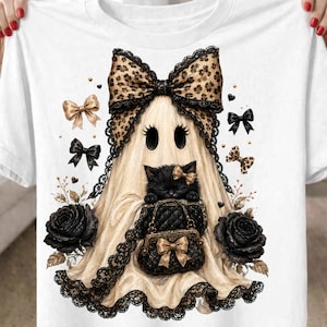 May include: A white t-shirt featuring a graphic of a ghost wearing a large leopard print bow. The ghost holds a black quilted handbag and a small black kitten. The design includes black lace trim, two black roses, and several small bows.