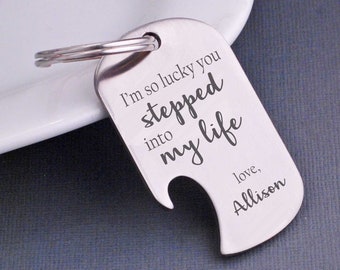 May include: A silver-colored metal keychain with a bottle opener. The keychain is engraved with the words "I'm so lucky you stepped into my life" and "love, Allison". The keychain is on a silver ring.
