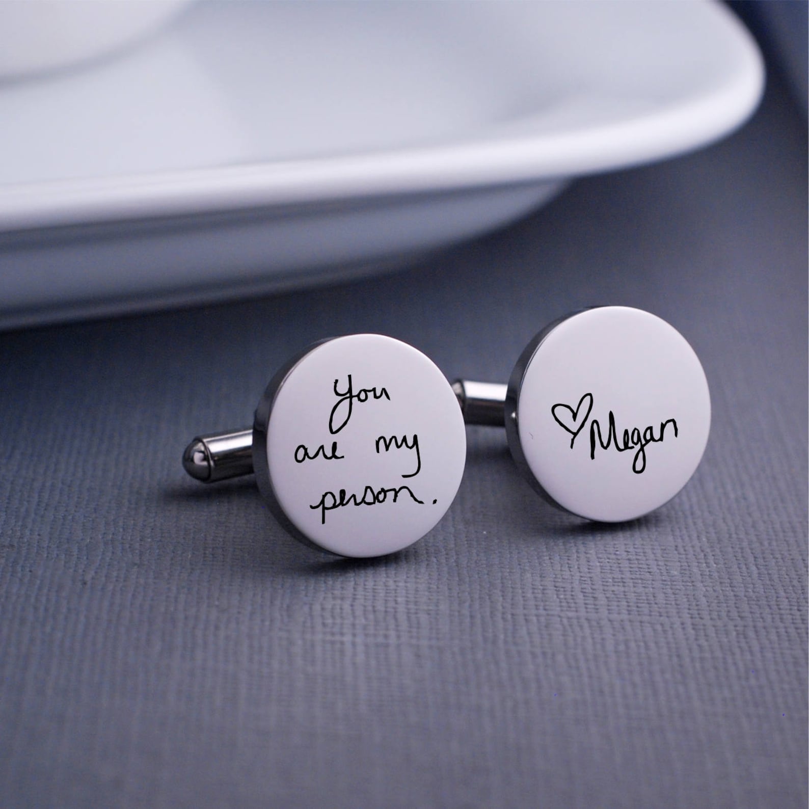 The handwriting of your choosing is engraved on stainless steel cuff links. These should be personalized with your own handwriting.