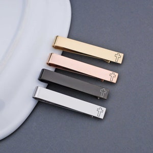 Engraved tie bar with a cross on the front. All colors shown. Gold, rose gold, gunmetal, and stainless steel.