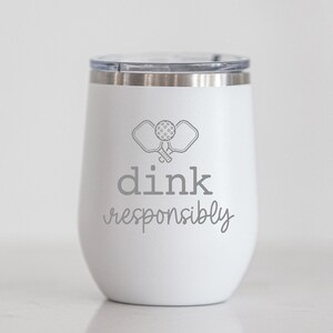 May include: White stainless steel tumbler with a gray graphic of two pickleball paddles and the text "dink responsibly".
