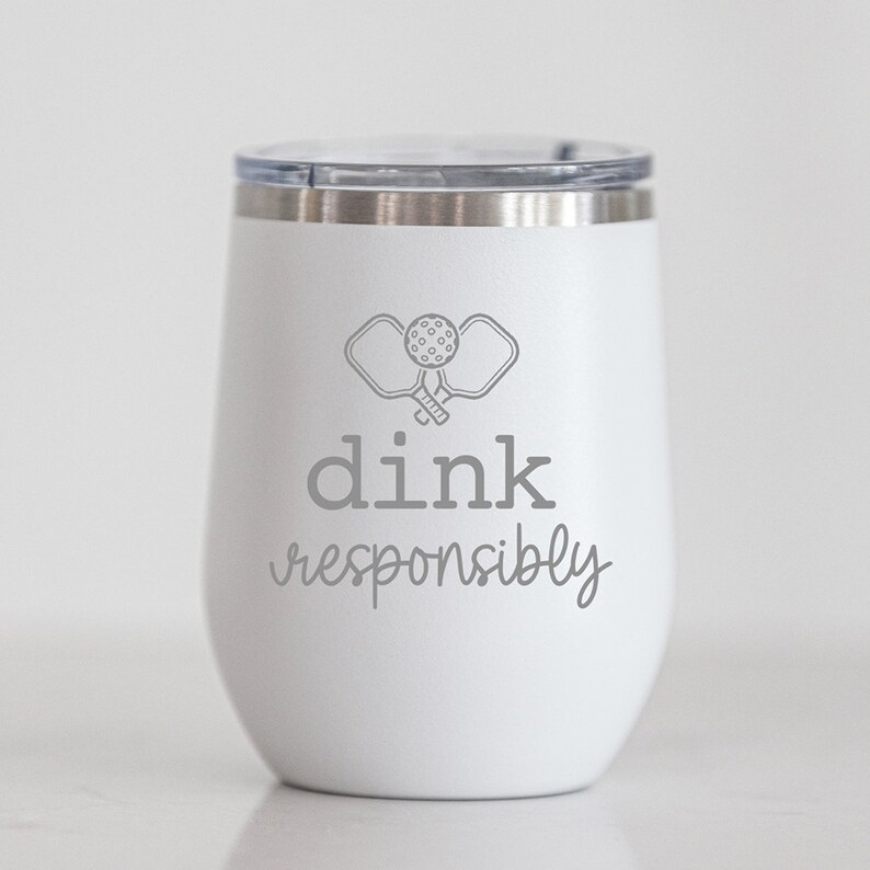 May include: White stainless steel tumbler with a gray graphic of two pickleball paddles and the text "dink responsibly".