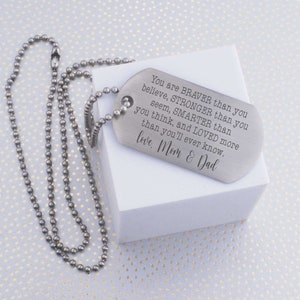 May include: Silver dog tag necklace with a message engraved on it that reads: "You are BRAVER than you believe, STRONGER than you seem, SMARTER than you think, and LOVED more than you'll ever know. love. Mom & Dad"