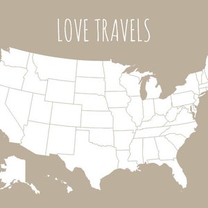 May include: A white outline map of the United States on a tan background. The text "LOVE TRAVELS" is written in a handwritten style at the top. The map includes state borders and the outlines of Alaska and Hawaii.
