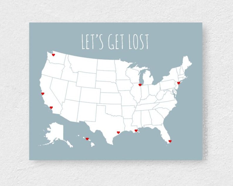 May include: A map of the United States with red heart markers on various locations. The phrase "LET'S GET LOST" is written in white script across the top of the map. The background is a light blue color.