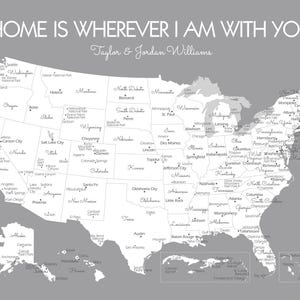 Op de afbeelding: Een grijze en witte kaart van de Verenigde Staten met de tekst "HOME IS WHEREVER I AM WITH YOU" en de namen "Taylor & Jordan Williams." De kaart benadrukt staten en steden.
