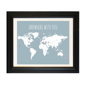 May include: A framed print with a world map and the text "Anywhere with you" in white lettering on a light blue background. Red heart-shaped pins are placed on the map.