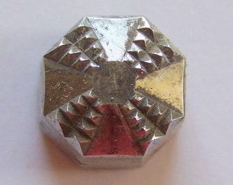 May include: A silver-colored, octagonal-shaped metal button with a textured, geometric design.