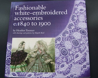 May include: Book cover with a purple background and white lace design. The title is "Fashionable white-embroidered accessories c.1840 to 1900" by Heather Toomer with drawings and patterns by Elspeth Reed. The cover features an illustration of two women in 19th-century clothing.
