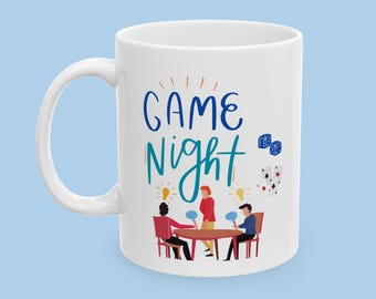 May include: White ceramic mug with a blue and green design that says "GAME NIGHT". The design also includes a group of people playing a game around a table, dice, and playing cards.
